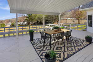 Back Wooden terrace featuring outdoor dining area and a mountain view