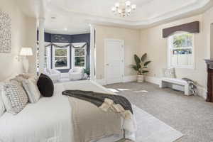 Primary Suite Carpeted bedroom featuring a raised ceiling and suspended lighting