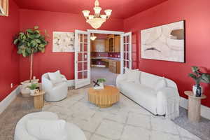 Living area with carpet flooring, french doors, and hanging lights