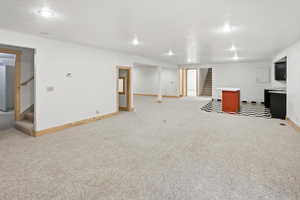 Finished below grade area featuring stairs and light colored carpet
