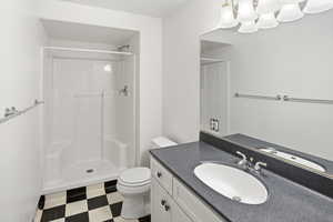Full bathroom with tile patterned floors, vanity, and a stall shower