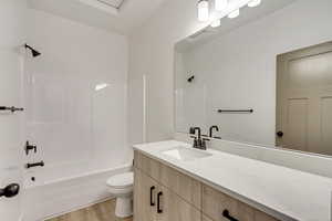 Bathroom with vanity, light wood finished floors, and shower / tub combination