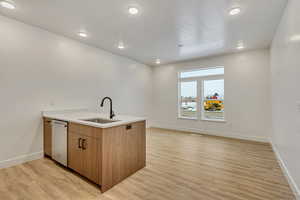 Kitchen with a peninsula, wood finish cabinets, light wood-style floors, recessed lighting, and dishwashing machine