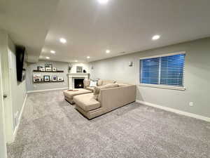 Carpeted living room featuring recessed lighting and a fireplace