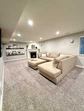 Living room featuring carpet flooring, a fireplace, and recessed lighting