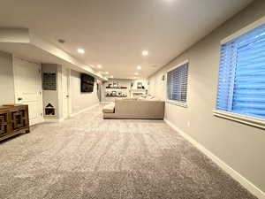 Living area with light colored carpet and recessed lighting