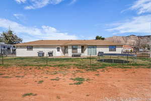 Rear view of property featuring a trampoline and a patio