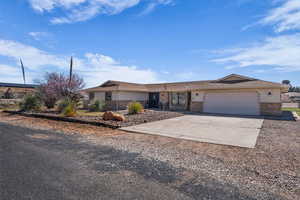 Ranch-style house with concrete driveway, a garage, and brick siding