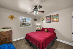 Bedroom featuring dark carpet and ceiling fan