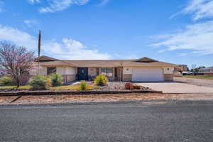 Single story home with driveway, a garage, and brick siding