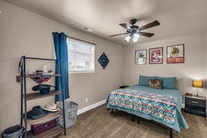 Bedroom with dark colored carpet and ceiling fan