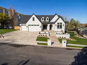 View of front of home with concrete driveway and an attached garage