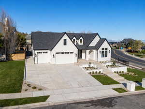View of front of home featuring driveway, a shingled roof, a garage, and covered porch