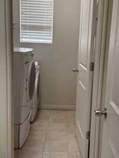 Laundry area with washer and clothes dryer and baseboards
