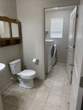 Bathroom with toilet and washer and clothes dryer