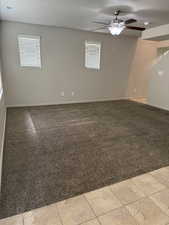 Unfurnished room featuring a ceiling fan, a textured ceiling, and light colored carpet