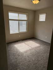 Carpeted spare room featuring a textured ceiling