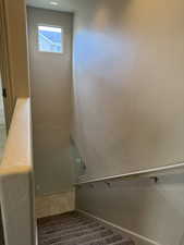 Staircase with tile patterned floors and baseboards