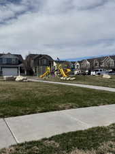 View of play area with a residential view and a lawn