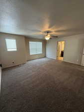Unfurnished bedroom featuring light colored carpet, a ceiling fan, and a textured ceiling