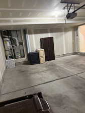 Garage with water heater, a garage door opener, and heating unit