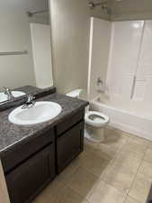 Bathroom featuring vanity, washtub / shower combination, and a textured wall
