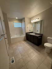 Bathroom with vanity, a textured ceiling, and shower / bathtub combination