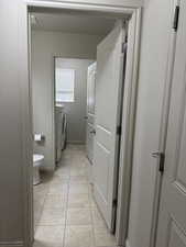 Half bath featuring toilet and separate washer and dryer
