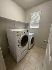 Laundry room featuring washing machine and clothes dryer and baseboards