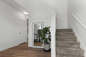 Staircase with wood finished floors and baseboards
