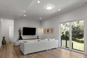 Living area featuring light wood-type flooring, recessed lighting, and a textured ceiling