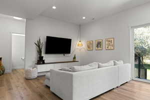 Living area with light wood finished floors and recessed lighting