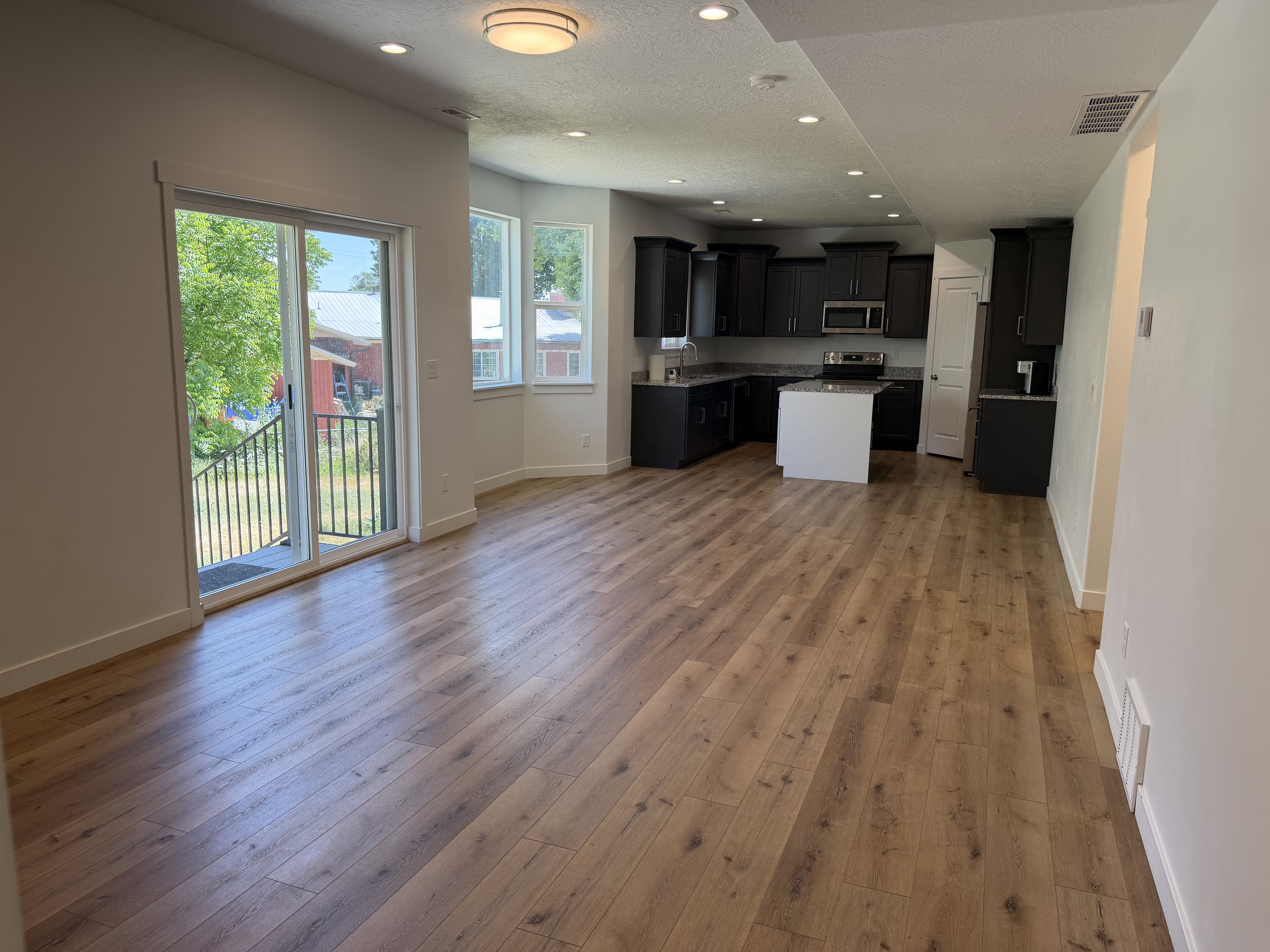 Open-concept living area featuring wood-finish flooring and recessed lighting