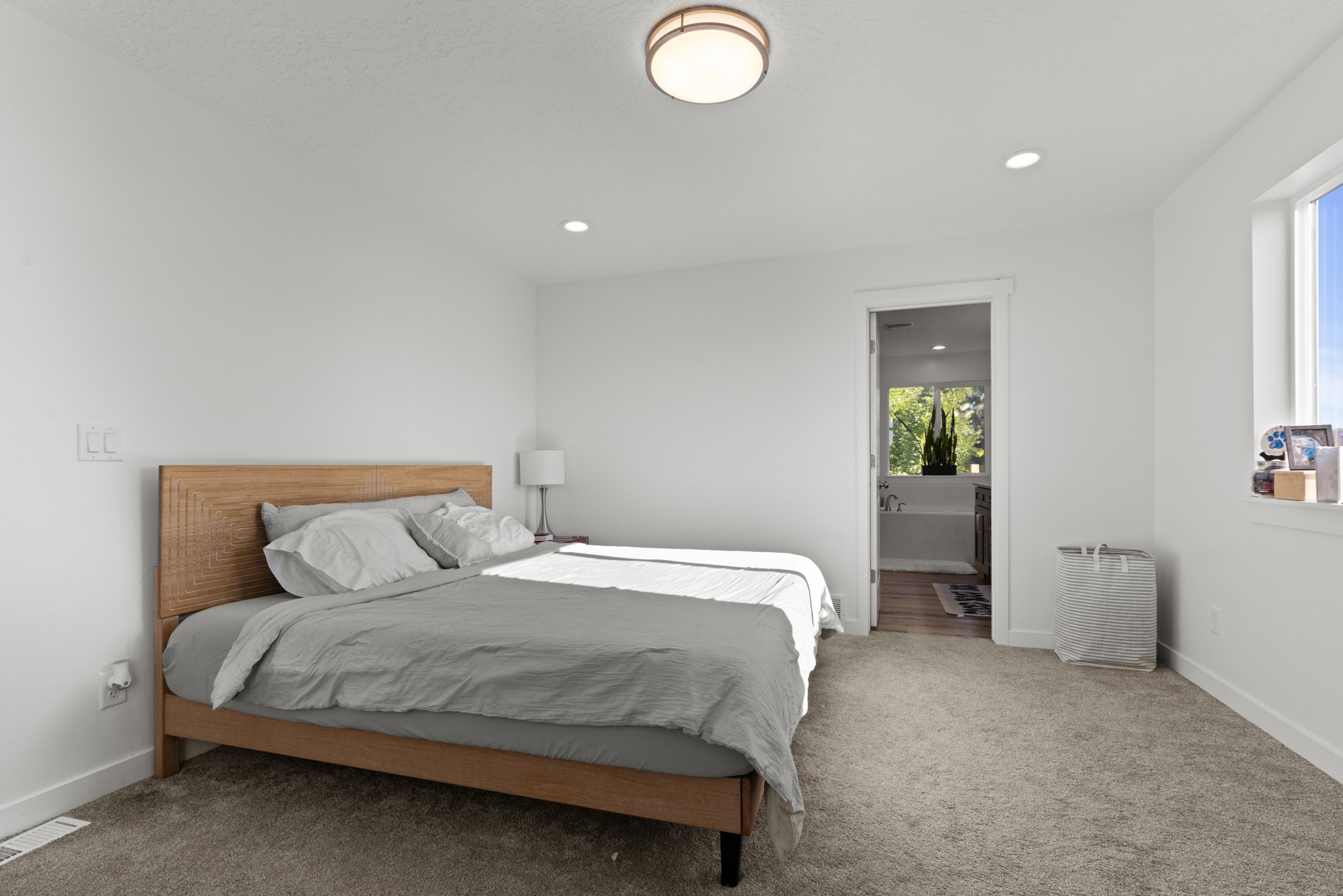 Bedroom with carpet flooring, ensuite bathroom, and recessed lighting