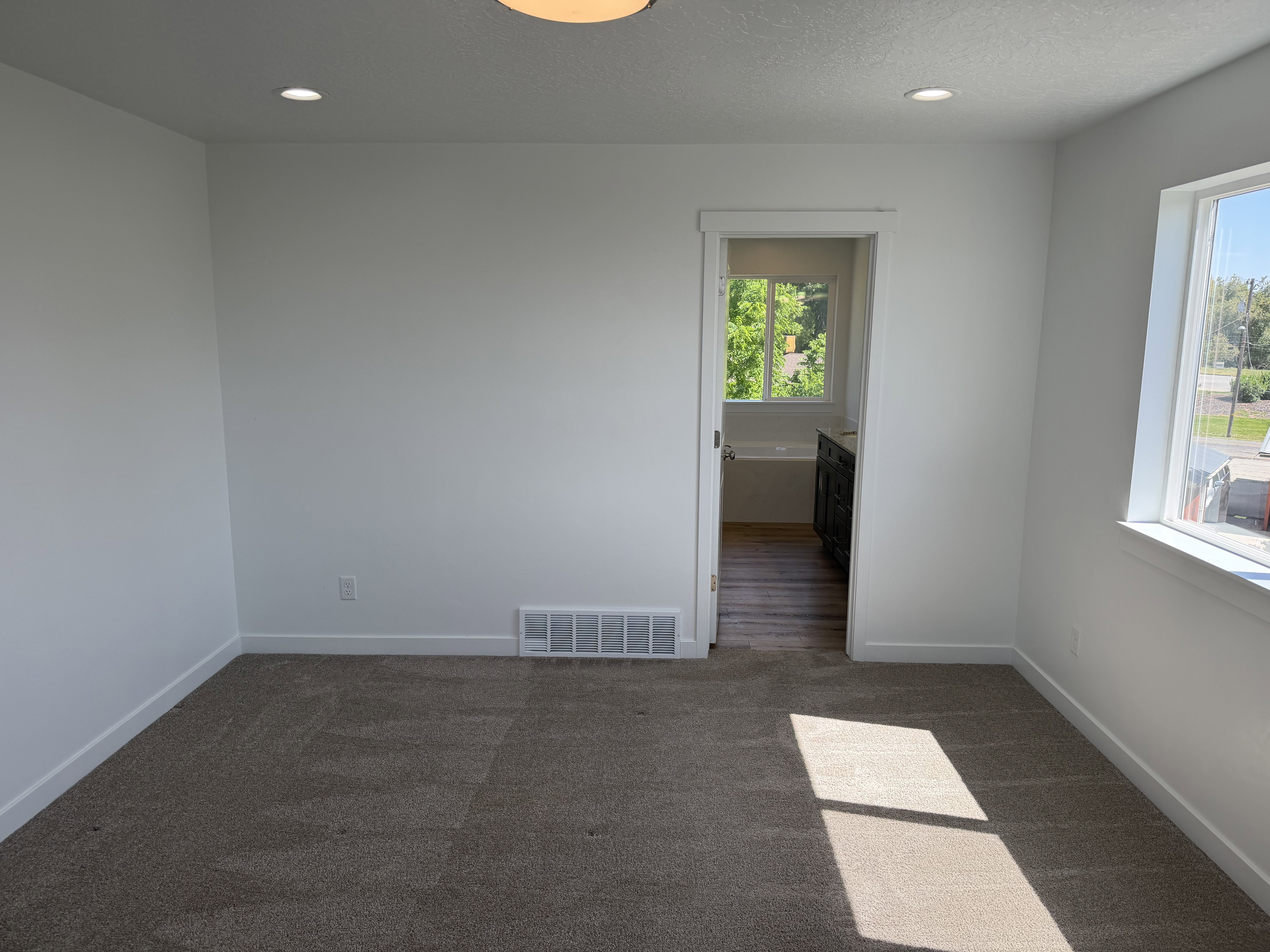 Carpeted room with recessed lighting and a flush-mount ceiling fixture