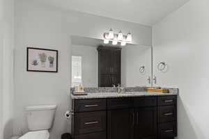 Half bathroom featuring vanity and toilet