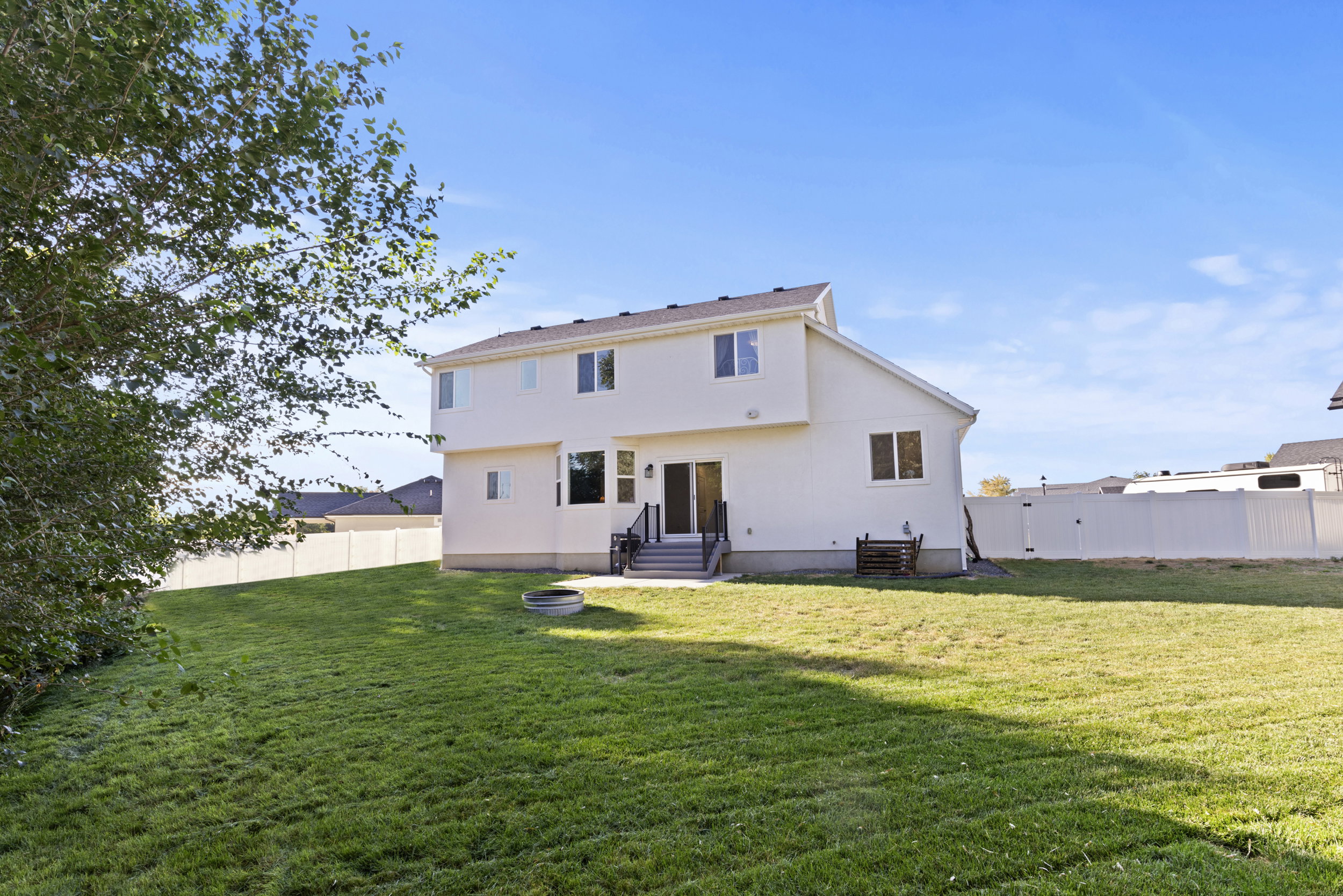 Back of property featuring a fenced backyard, entry steps, and stucco siding