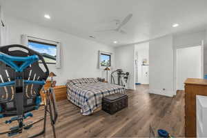 Bedroom featuring wood-type flooring, ceiling fan, recessed lighting, and ensuite bath