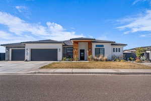 Prairie-style house featuring an attached garage, driveway, and stucco siding