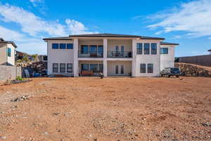 Rear view of house with french doors, stucco siding, a patio, and a balcony