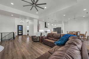 Living room featuring a ceiling fan, hanging lights, dark wood finished floors, and washer / clothes dryer