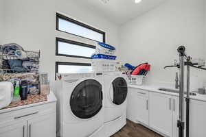 Laundry area with cabinet space, washing machine and dryer, and dark wood-type flooring