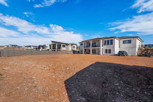 Back of property featuring stucco siding, a residential view, and a balcony