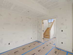 Unfurnished room with stairway and baseboards