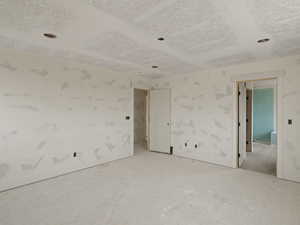 Spare room with baseboards and a textured ceiling
