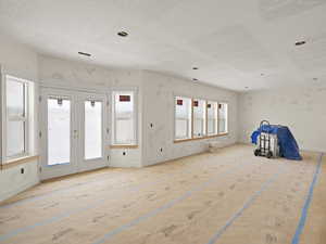 Empty room featuring baseboards and french doors