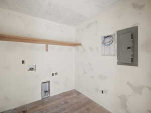 Laundry area with electric panel, wood finished floors, washer hookup, a textured ceiling, and gas dryer hookup