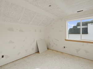 Bonus room with vaulted ceiling and baseboards