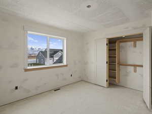 Unfurnished bedroom featuring a closet and a mountain view