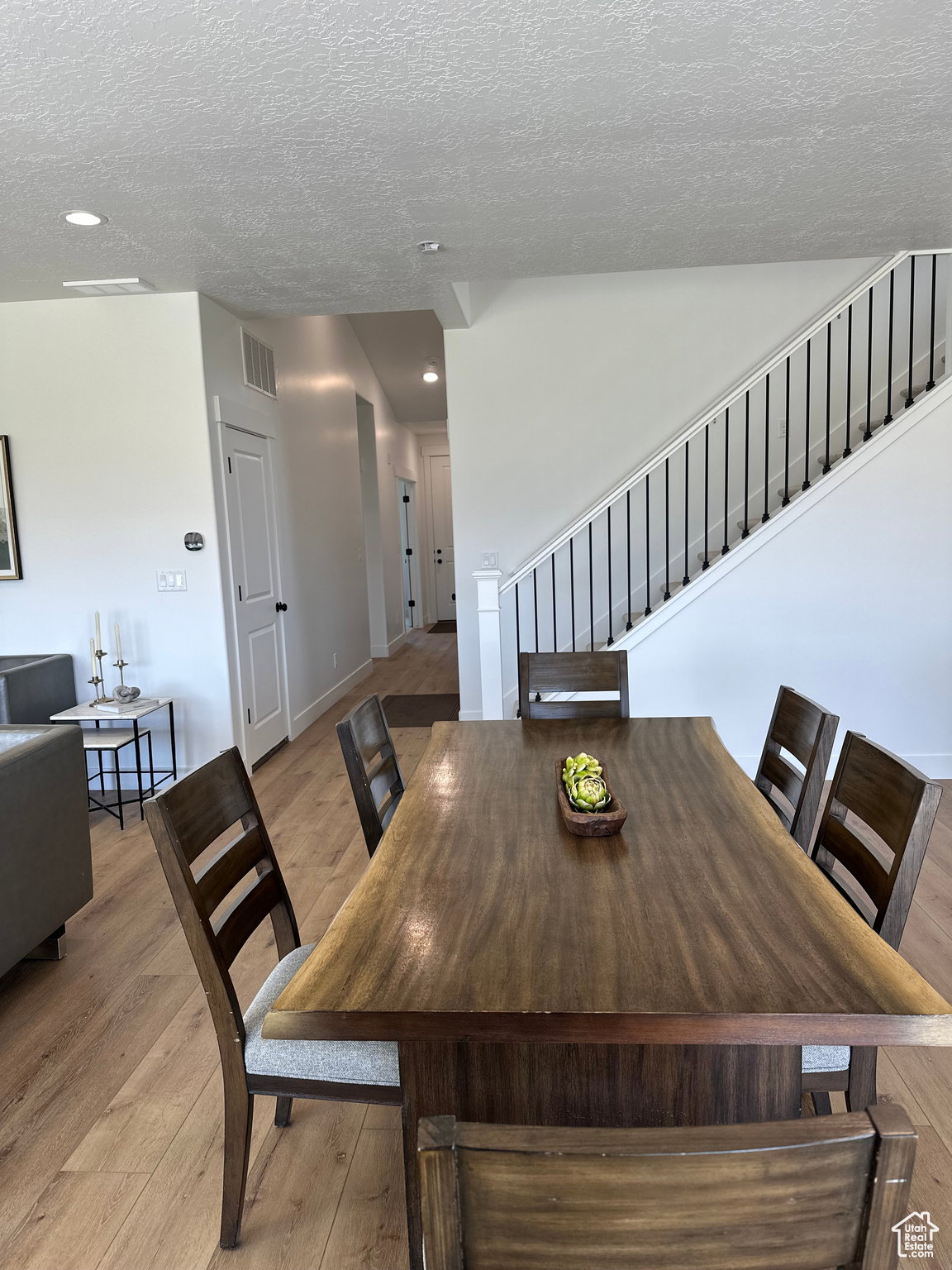 Dining area featuring light wood-style floors, a textured ceiling, and recessed lighting